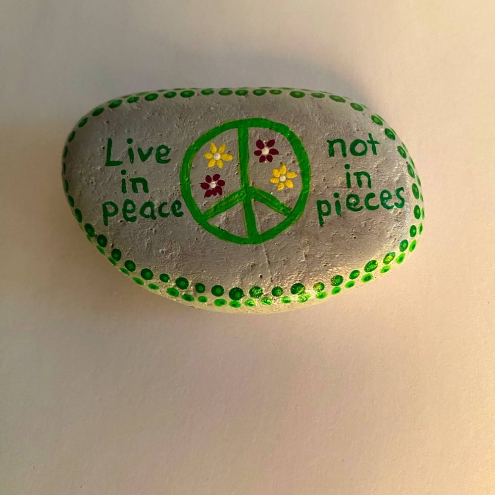 Hand painted peace sign on river rock